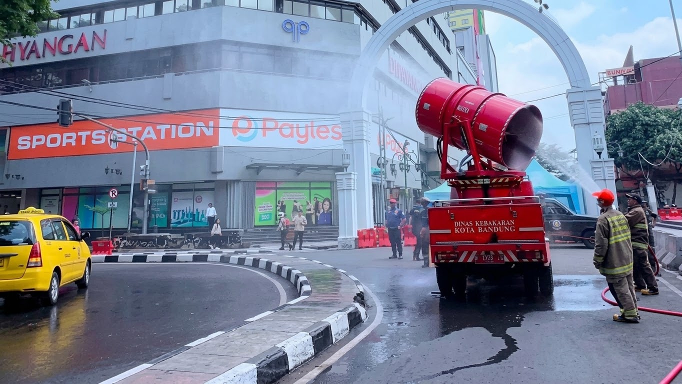 1Petugas Diskarmat Kota Bandung menyemprotkan air ke trotoar jalan untuk membersihkan debu vulkanik Anak Gunung Krakatau