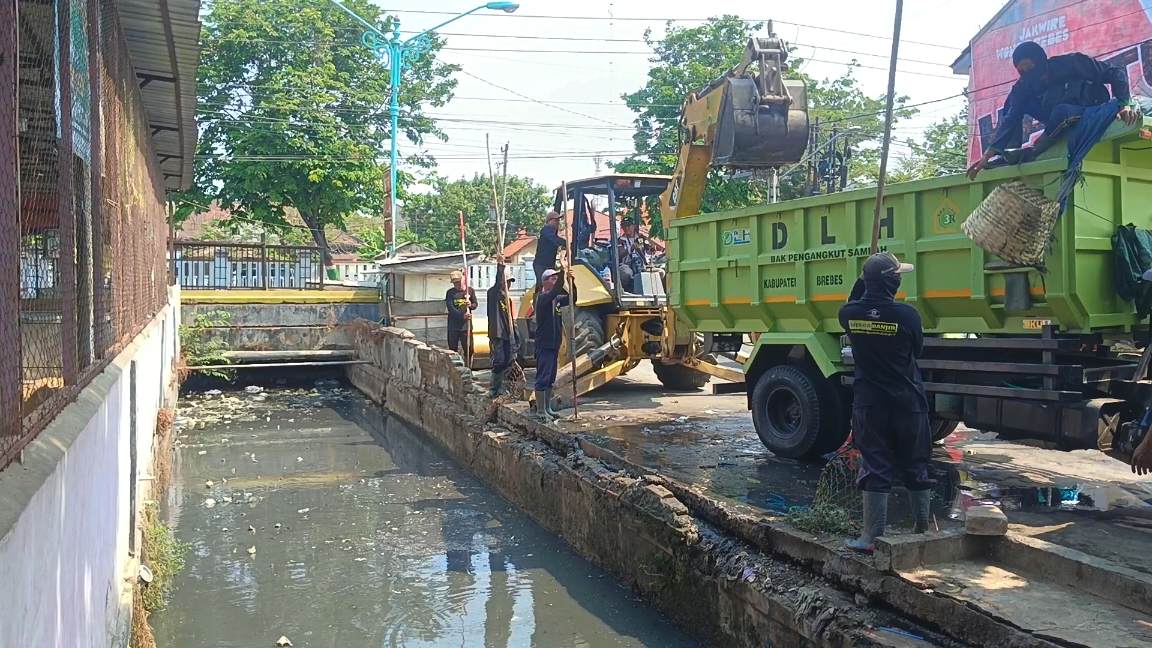 Petugas membersihkan saluran irigasi yang mampet di kawasan pusat kota Brebes
