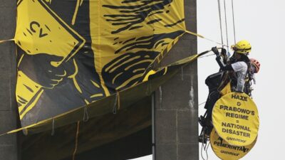 Aktivis Greenpeace Indonesia membentangkan spanduk kritik krisis iklim di Patung Selamat Datang, Bundaran HI, Jakarta, Selasa 20 Oktober 2026.