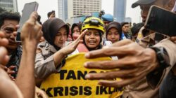 Aktivis Greenpeace Indonesia membentangkan spanduk kritik krisis iklim di Patung Selamat Datang, Bundaran HI, Jakarta, 20 Oktober 2026.